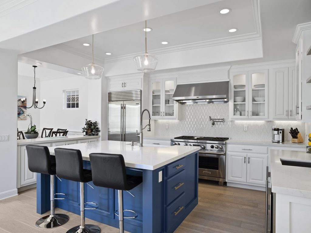 Modern kitchen with blue cabinets, large center island and white tiled backsplash