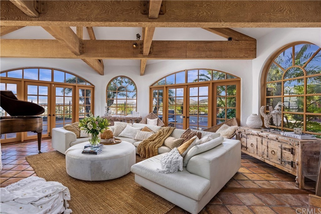 Living room with wood beamed ceilings and large windows 