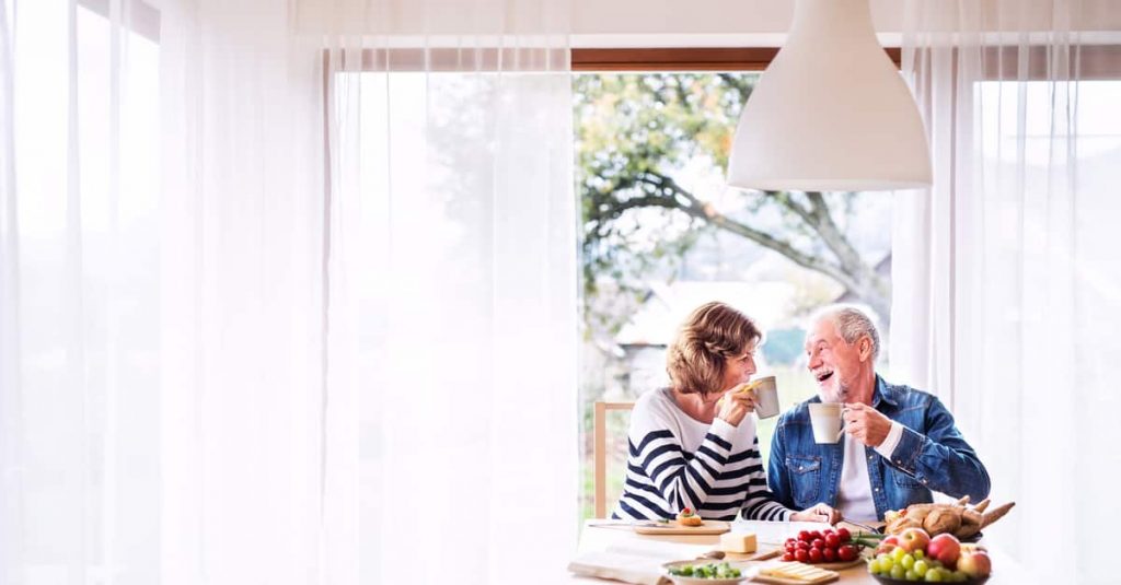 Senior couple eating breakfast at home.