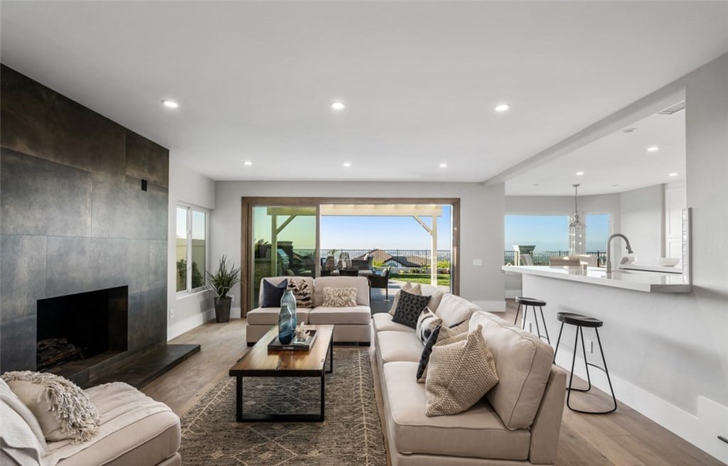 Living room with focal point fireplace opening to backyard with endless views