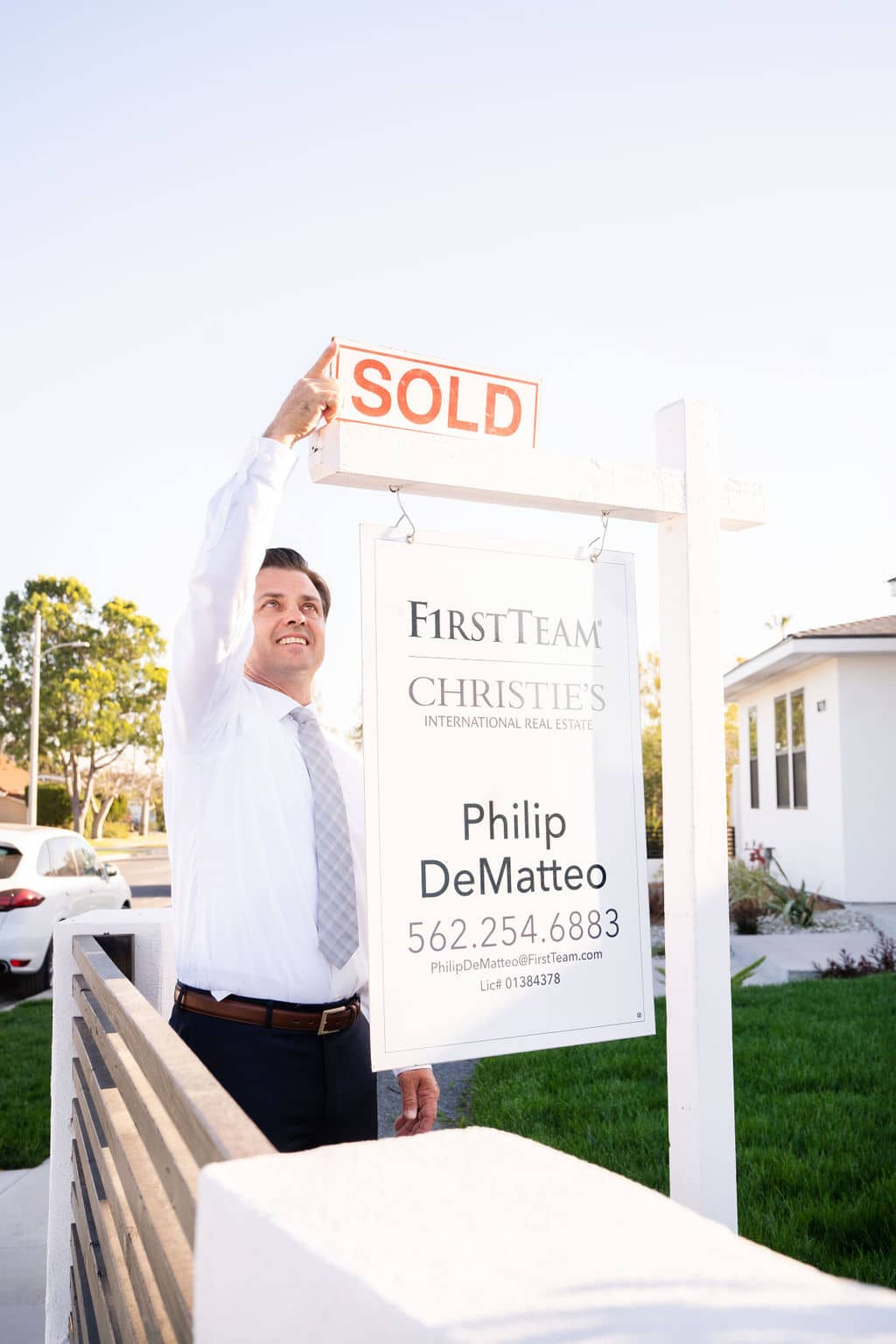 Philip Dematteo Hanging A Sold Sign Rider On A For Sale Sign