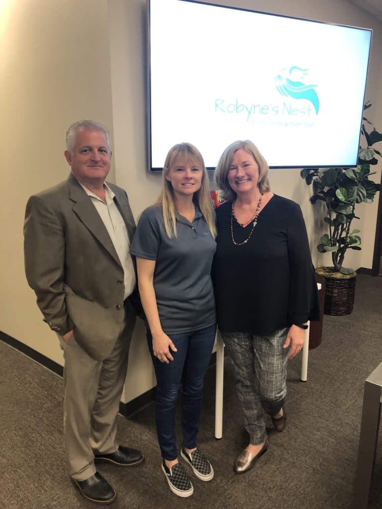 Tim Branoff, Robyne Wood, Karen Branoff Standing In Front Of Robyne'S Nest Background On Tv