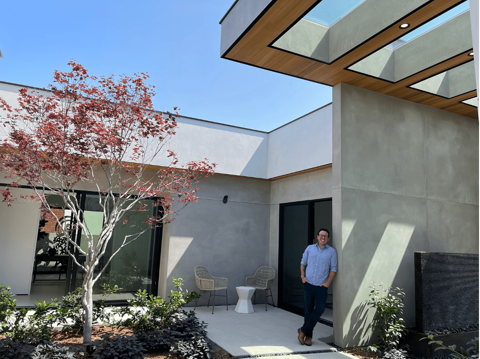 Designer Mathew Mcgrane Leaning Against A Post Within The Courtyard